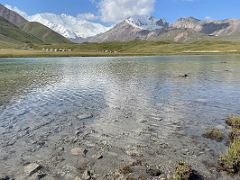 07D The clear water of Tulpar Lake and yurts among green fields with Lenin Peak and Pik Petrovski on day hike from Ak-Sai Travel Lenin Peak Base Camp 3600m